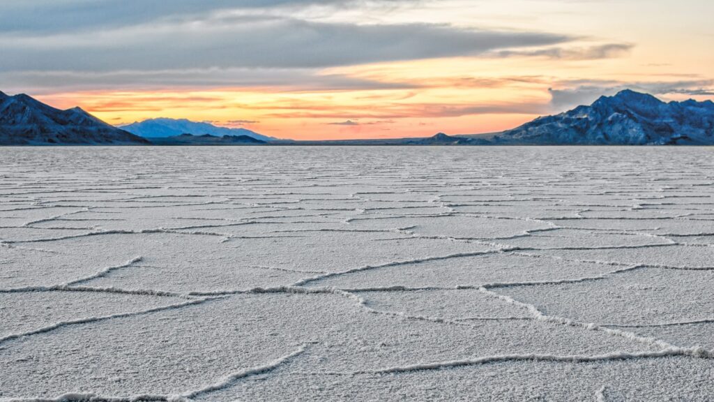 Salt flats at sunset in Tooele County, with mountains along the horizon