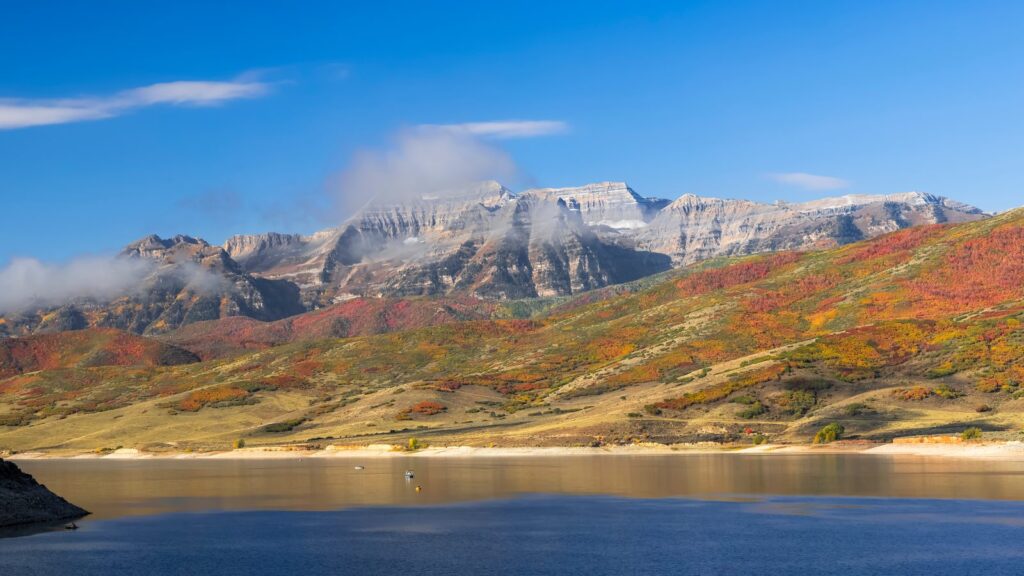 A snow-covered ridge above a reservoir in Wasatch County, with autumn colour on the slopes